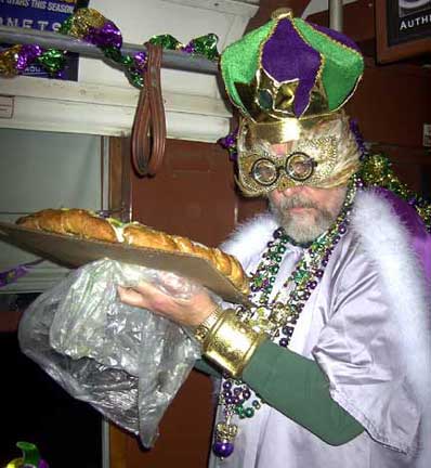 Twelth Night Celebration Boss of the Phunny Phorty Phellows passes out a King Cake to find out the boss for the next year